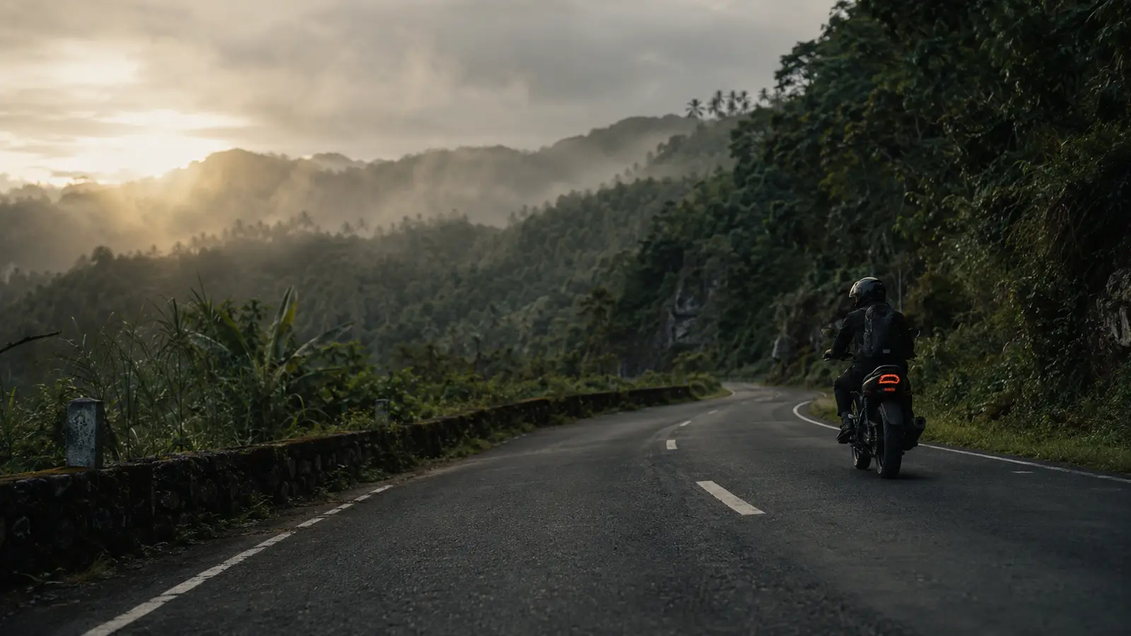 A motorcycle rider following a mountain road in the Philippines